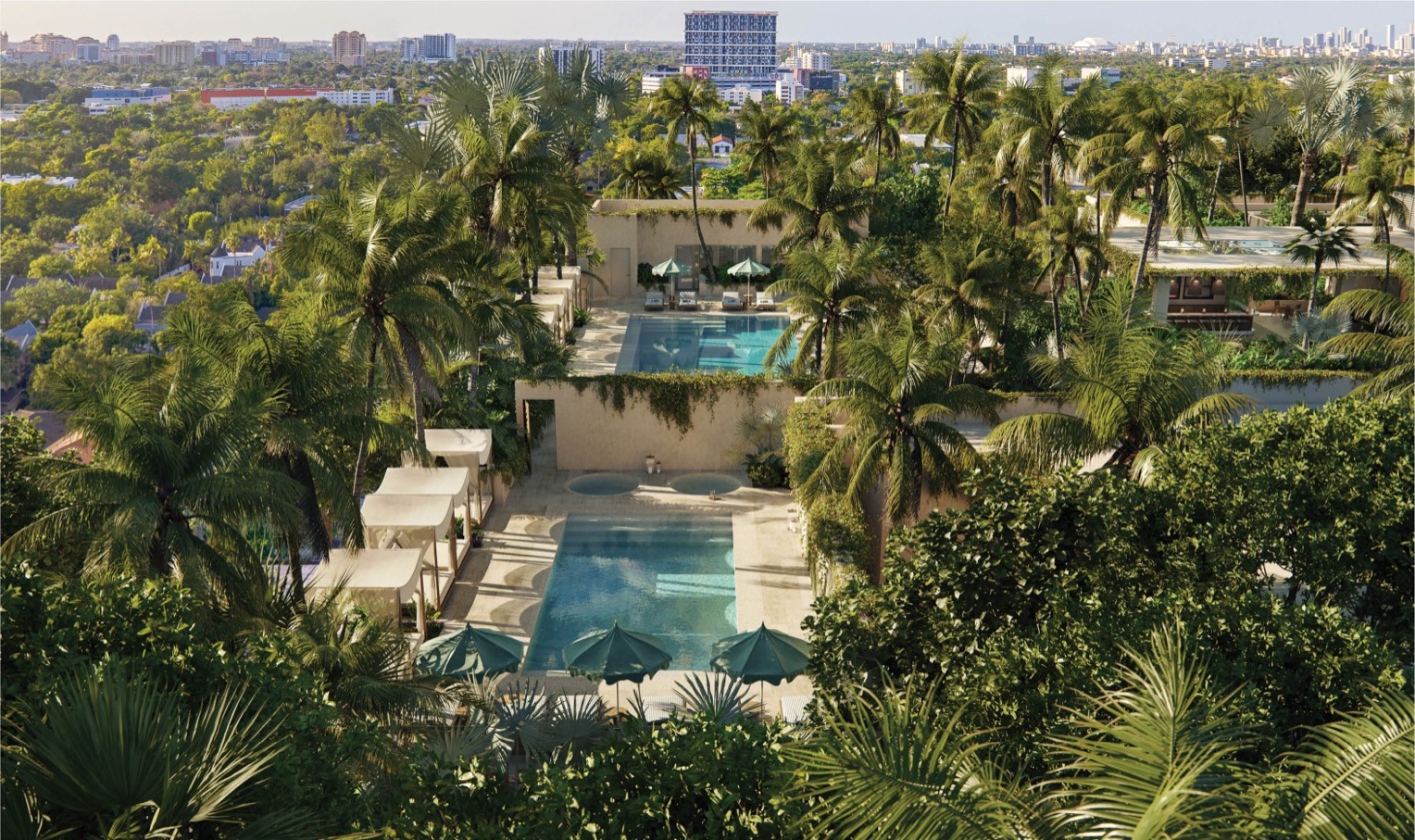 Rooftop pool deck at THE WELL Coconut Grove — 40,000 sf wellness oasis with private cabanas, hot and cold plunges, and rooftop bar.